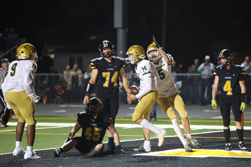 Bishop McNamara's Richie Darr (5) and Julius May (9) celebrate a touchdown by teammate Karter Krutsinger, center, during the Fightin' Irish's 45-28 victory over Herscher on Friday, Sept. 5, 2025.