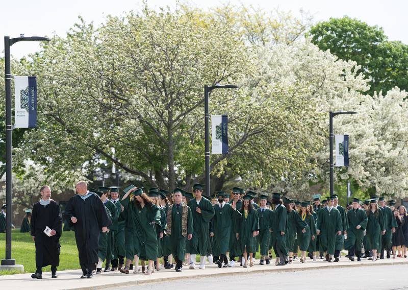 Graduates march to the football field before a graduation ceremony for the class of 2022 on Saturday, May 14, 2022, at Crystal Lake South High School in Crystal Lake.