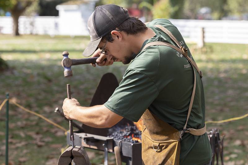 Danny Tesar of Prairie Du Chien, Wis., works on a project Saturday, Oct. 12, 2024, at the John Deere Historic Site’s Fall Fest. Tesar came down with his father Dan to display their traditional blacksmithing skills.