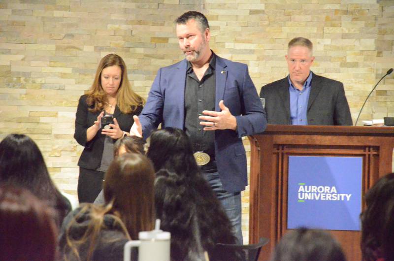Kane County Sheriff Ron Hain addresses Aurora University students Monday morning. Background (from left) are State's Attorney Jamie Mosser and Brandon Kooi, criminal justice professor, who moderated the session.