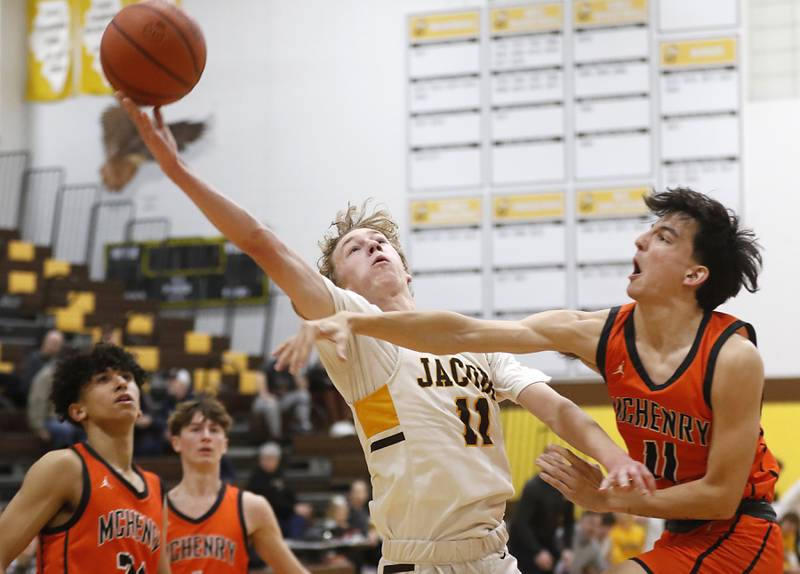 Jacobs' Max Fessler drives to the basket against McHenry's Hayden Stone during a Fox Valley Conference boys basketball game on Wednesday, Nov. 29, 2023, at Jacobs High School in Algonquin.