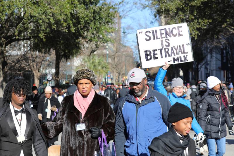 FILE - A marcher holds up a sign at a march and rally at the South Carolina Statehouse to honor Martin Luther King Jr. on his holiday on Monday, Jan. 20, 2025, in Columbia, S.C. (AP Photo/Jeffrey Collins, File)