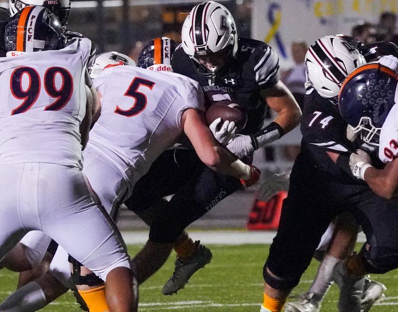 Oswego’s Carson Cooney hits Plainfield North's Robert Tota in the backfield for a loss during a football game at Plainfield North High School on Friday, Sept. 22, 2023.