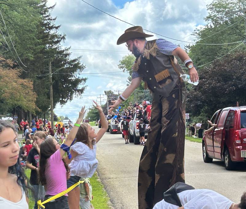 Stiltwaker Jason Kollom gets a high five from a parade watcher during the German Valley Days parade on Saturday, July 19, 2025.