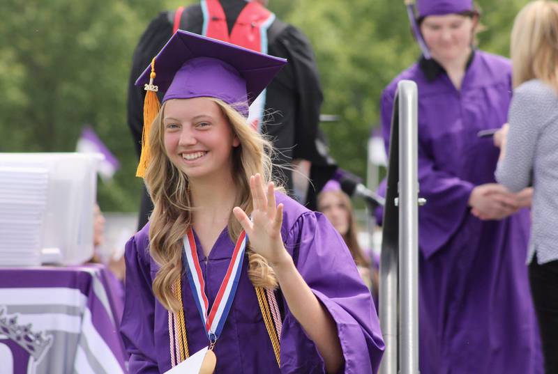 Leah Kuehl, valedictorian, waves to the crowd after accepting her medallion and diploma on Sunday, May 28, 2023, during Dixon High School commencement.