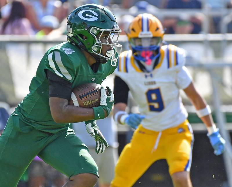 Glenbard West’s Jamarcus Kelly sweeps the right side past Lyons Township defender Miko Zecevic (9) during a game on September 27, 2025 at Glenbard West High School in Glen Ellyn.