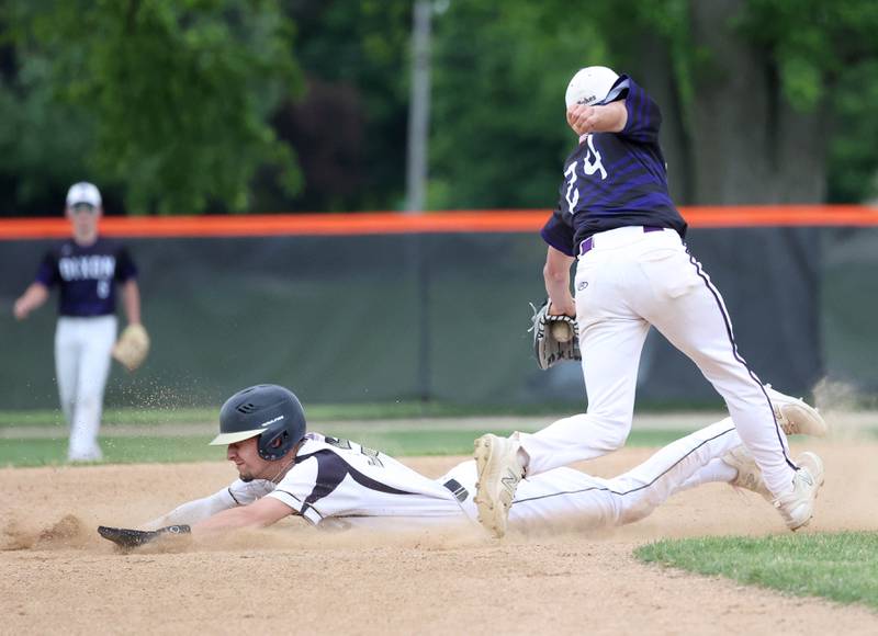 Sycamore's Trenton Meisch slides in safely with a stolen base as Dixon's Brady Feit tries to make the tag Thursday, May 29, 2025, during their Class 3A regional semifinal game at Freeport High School.