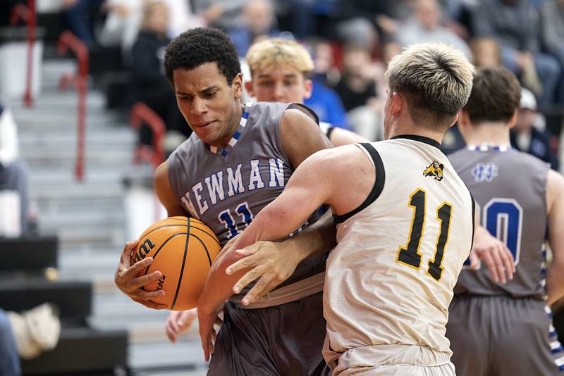 Newman’s Tyson Williams gets tangled up with Riverdale’s Brady Junis Tuesday, Dec. 30, 2025, in the final of the boys Cliff Warkins Basketball Tournament at Erie High School.