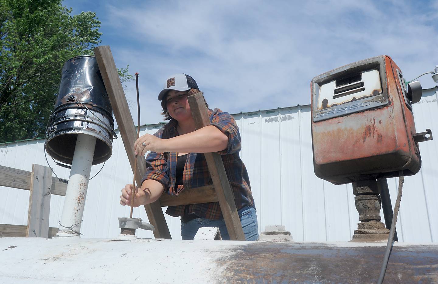 Destiny West checks how much diesel fuel is left in the storage tank Friday, June 10, 2022, at a farm near Richmond. The rising cost of nitrate and fuels is raising farmers' operational costs.