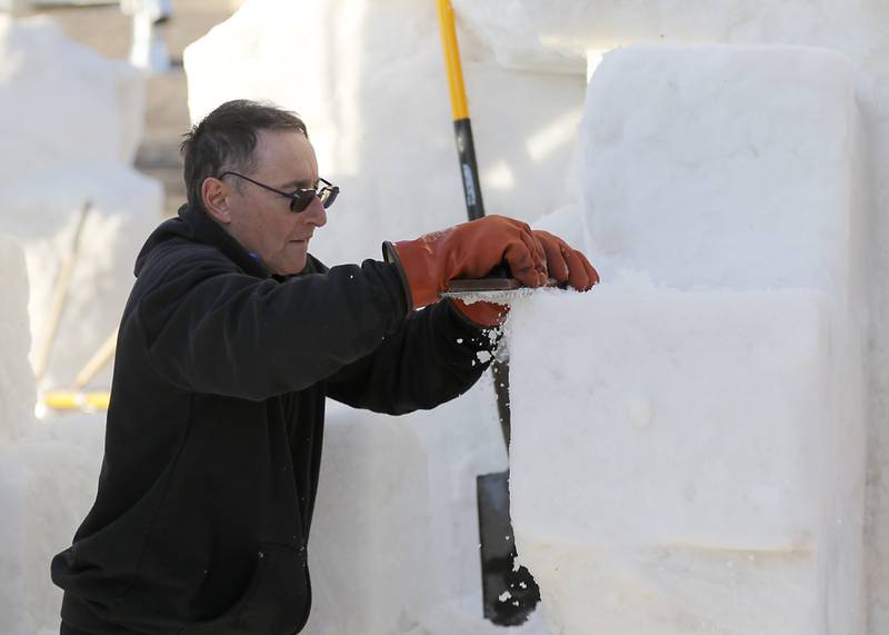 Wisconsin snow carver Mike Lechtenberg works his teams sculpture “Creativity Come To Life” on Thursday., Jan. 30, 2025, Snow carvers have started carving their 15 massive snow sculptures on for America’s Snow Sculpting Invitational during Winterfest in Lake Geneva. Winterfest, runs through Feb, 2, 2025. The warm and rainy weather has slowed down the carving of the snow.