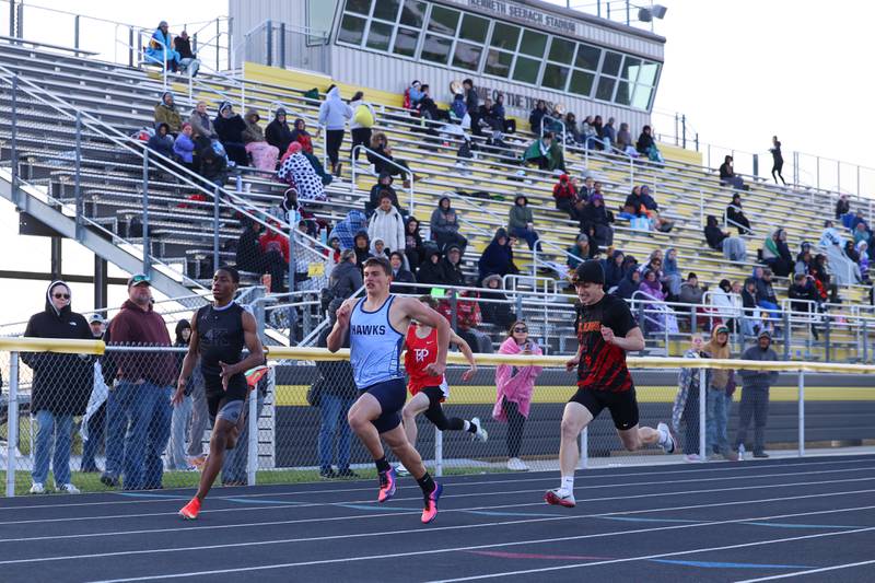 Kankakee's George Noble, left, and St. Anne's Aden Pinson, right, stride out as Prairie Central's Collin Kilgus holds down the lead during the final heat of the 100-meter dash at the Herscher Track Invite on Friday, May 1, 2026.
