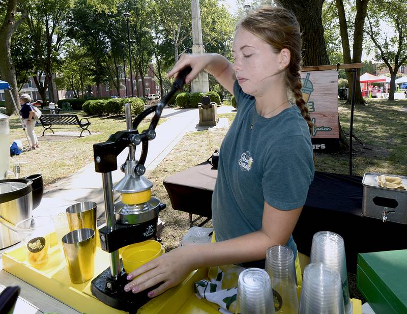 With temperatures in the 90’s, Maxine Bland had the right idea for her business as she squeezes another lemon to make a lemon shake up for a customer Saturday at Washington Park in Ottawa during the 4th annual Children’s Business Fair.