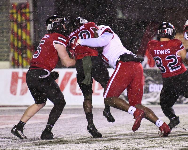 NIU QB Nevan Cremascoli, left, hands the ball off to running back teammate Harrison Waylee in the first quarter Wednesday Nov. 16 that was fumbled in the endzone resulting in a safety for Miami of Ohio at Huskies Stadium in DeKalb.