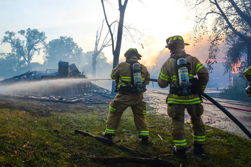 Firefighters spray down flames at a multi-unit fire Monday, May 30, 2022, at Grand Bear Resort in Utica.