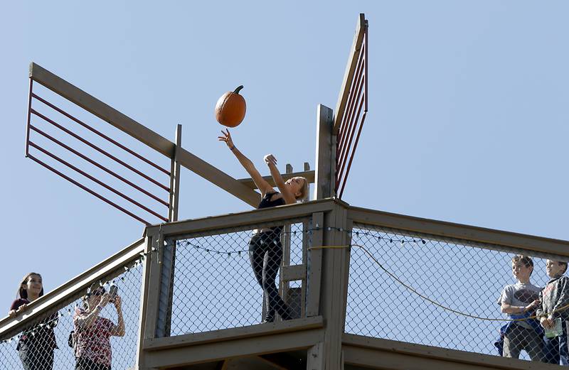 Annalee Aarseth, 14, of Crystal Lake, tosses a pumpkin off a 50-foot observation tower on Monday, Oct. 10, 2022, at Richardson Adventure Farm, 909 English Prairie Road in Spring Grove. The farm's main attraction is a James Bond-themed corn maze, but it also features train rides, a carousel, picnic areas, wagon rides, a zip line, 150- and 100-foot slides, zorbing, a petting zoo, pumpkin patch, goat feeding area, pedal kart tracks, live music on weekends, a kid's play area, jumping pillows, pig races, air cannons, a paintball shooting gallery, indoor restrooms, gift shop and wine tasting bar.