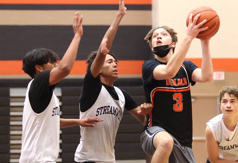 DeKalb's Cooper Phelps shoots over a pair of defenders during their game with Streamwood Tuesday, June 6, 2022, in a summer tournament at DeKalb High School.