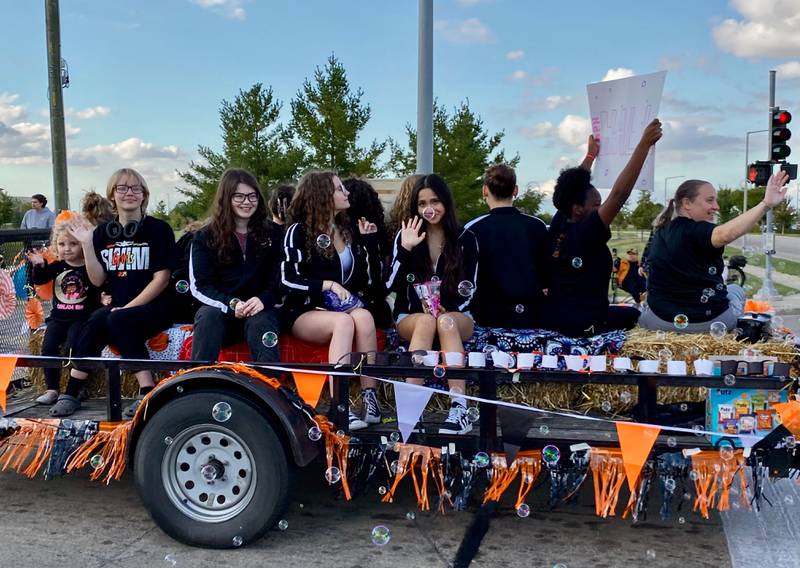 DeKalb High School students wave and blow bubbles during the annual DeKalb High School Homecoming Parade on Wednesday, Sept. 24, 2025, along West Dresser Road.
