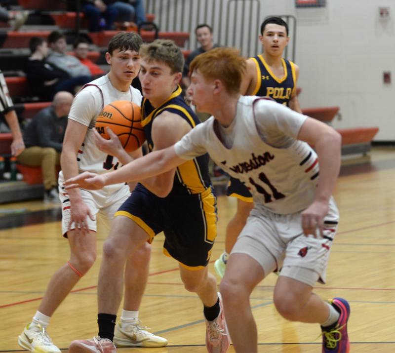 Polo's Gage Zeigler (3) protects the ball from Forreston's Kendall Erdmann (left) and Connor Politsch (right) on Tuesday, Jan. 7, 2024 at Forreston High School.