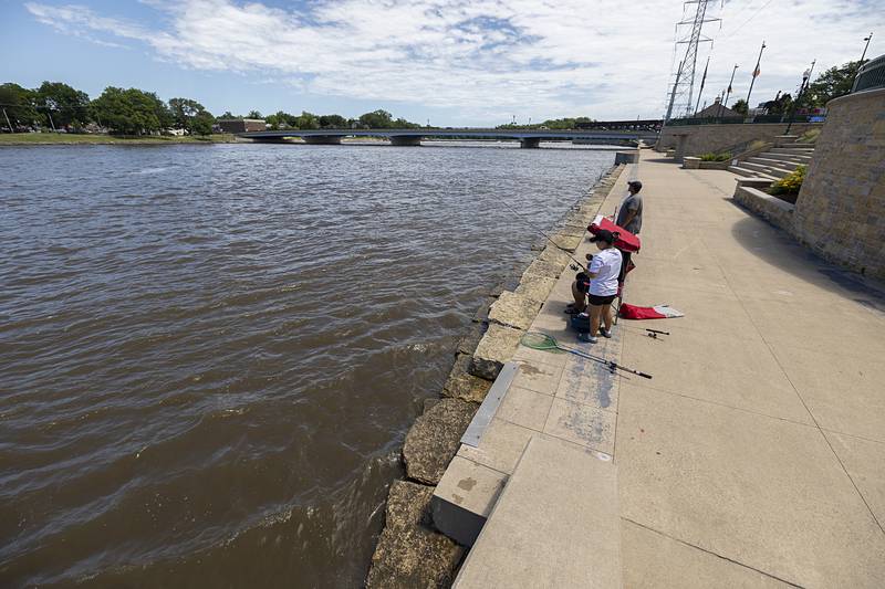 Anthony Vargas, Roselle Baracoso and Mikey Soria of Chicago try their luck along the Rock River in Dixon Wednesday, June 26, 2024 near where the dock normally sits. Crews removed the dock for repairs after a tree speared the structure.