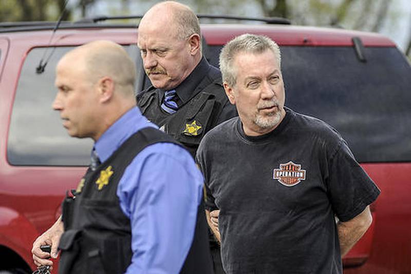 State police Lt. Carl Anderson (left) along with another investigator escort Drew Peterson into District 5 State Police headquarters Thursday evening. Peterson was arrested during a traffic stop and charged with the March 2004 murder of his third wife Kathleen Savio.