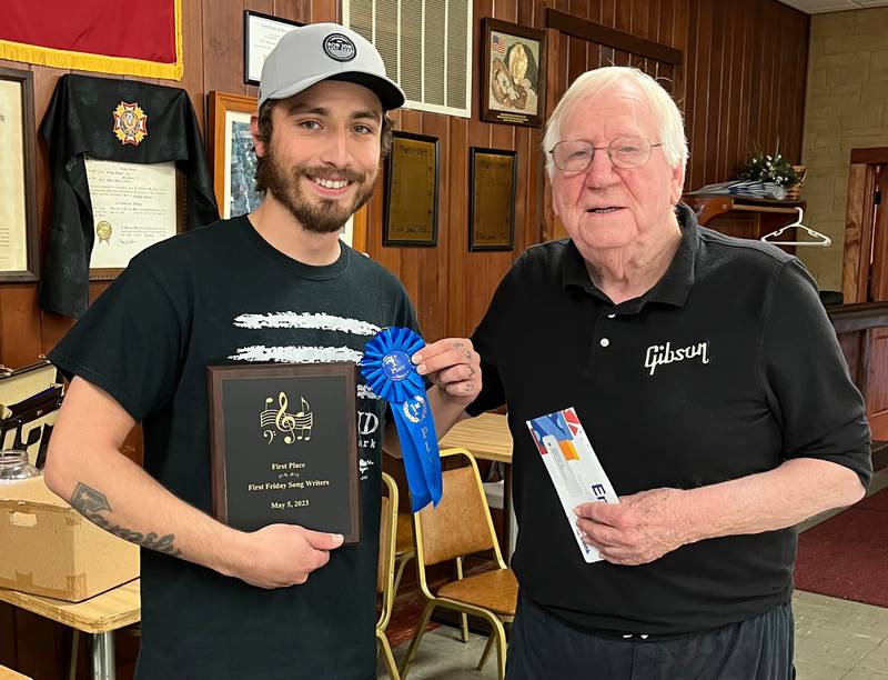 Adrian Barragan, pictured here with First Fridays’ host Jerry Tice, was the winner of last month’s songwriters’ contest. Kim Eastabrook and Sophie Coyote took second and third place honors out of a field of eight contestants.
