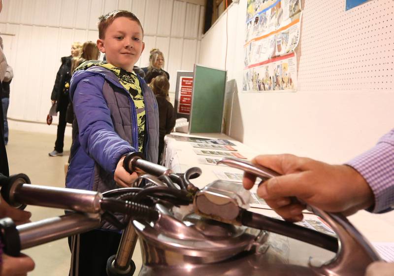 Travis Carlson of Bureau Valley Elementary School places his thumb inside an electric cow milking machine during the Bureau County Ag. Fair on Thursday, March 21, 2024 in Princeton. The Ag Fair is a daylong event at the Bureau County Fairgrounds in which students make times stops at multiple stations. There are fourteen different learning centers specializing in dairy, embryology, safety, pork, corn, seed science, conservation, beef, soybeans, pollination, technology, equipment, and large and small animals.