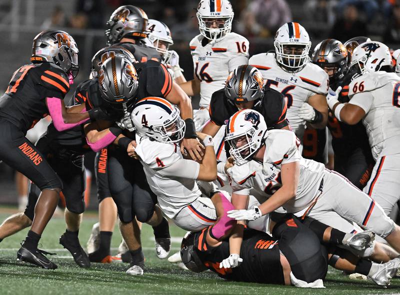 Oswego's Drew Kleinhans (4) gets tackle by a host of Minooka's defenders during the conference game on Friday, OCT. 10, 2025, at Minooka.