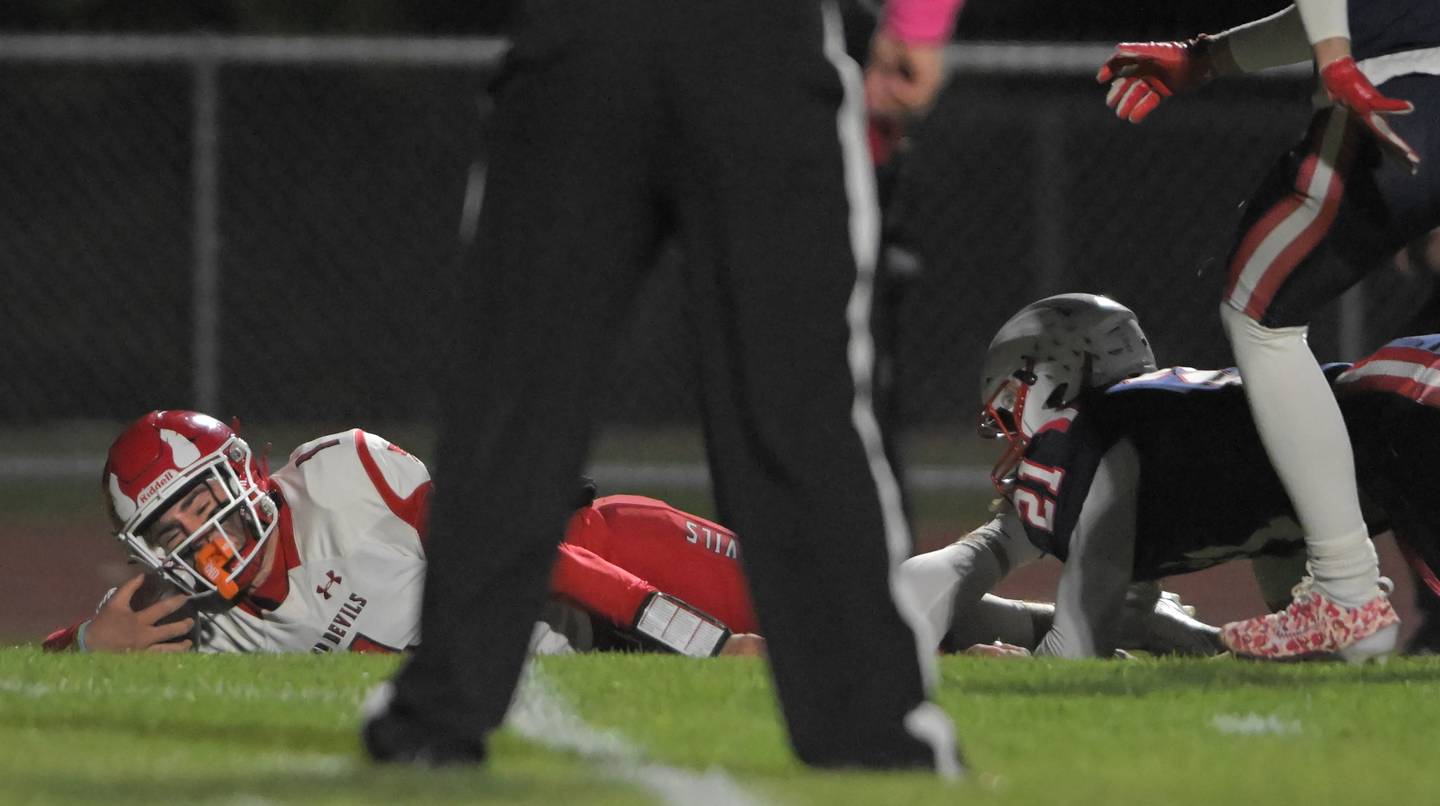 Hinsdale Central's Riley Contreras dives for a touchdown as South ElginÕs Silas Berrios and Nick Dodge hold his legs in an IHSA Class 8A playoff football game in South Elgin on Friday, Oct. 31, 2025.