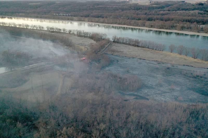 Smoke and charred timber burns from a large brush fire that broke out near the 12000 block of West Bottom Road on Monday, March 2, 2025 near Granville. The fire was elevated to the second alarm as the flames spread further west. Over 150 acres of timber burned along the Illinois River during the incident.