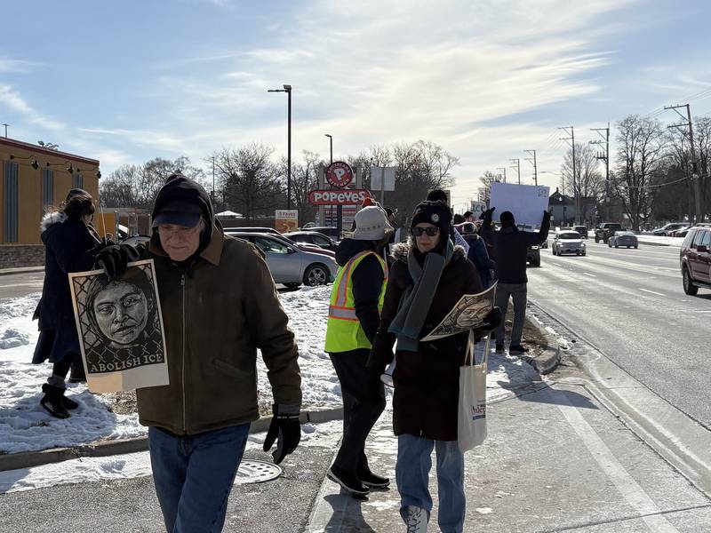 Protesters hold signs during a protest in McHenry Feb. 1, 2026.