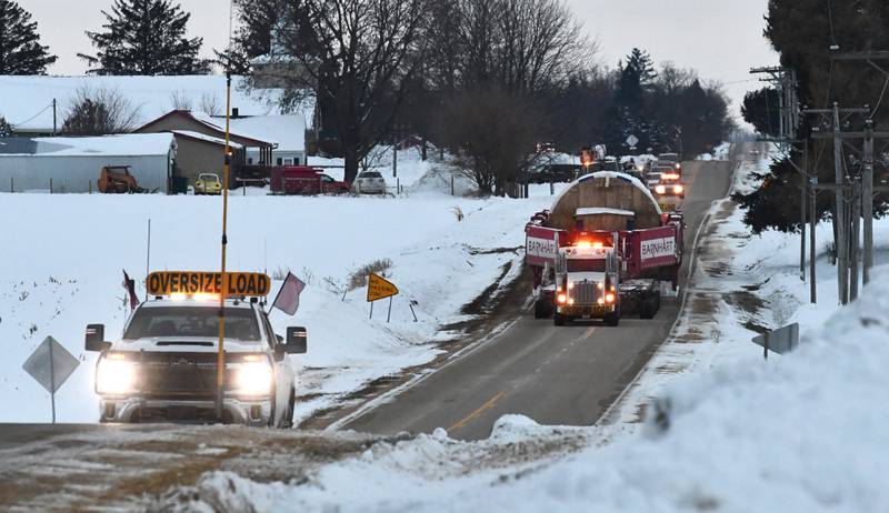 Two semi tractors pulling and pushing the trailer carrying a large turbine for Constellation's Byron generating station head north on German Church Road en route to the nuclear power plant on Monday, Dec. 8, 2025.