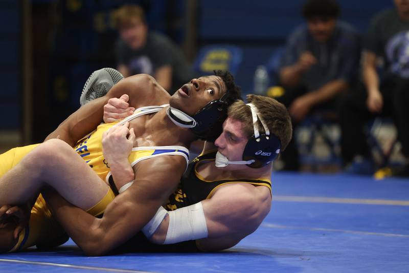 Joliet West’s Tristan Radeke works behind Joliet Central’s Mark Bew in the -pound weight match at Joliet Central on Friday, Jan 31, 2025.