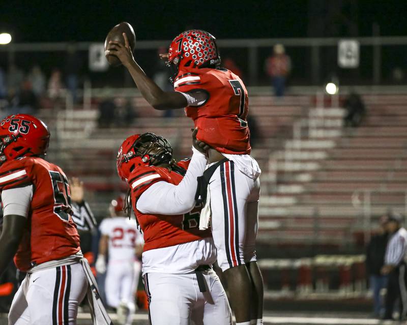 Bolingbrook's Tyson Ward (7) is lifted up while celebrating a touchdown run during football game between Yorkville at Bolingbrook Friday, Oct 24, 2025 in Bolingbrook.