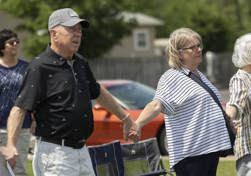 Roger and Carla Hill of Dixon hold hands during a singing of “God Bless the USA” on Sunday, June 8, 2025, during the dedication of legacy stones at Veterans Park in Dixon. The Hills dedicated a stone to honor their son, Ryan, a combat medic who suffered from post-traumatic stress disorder and died last August.