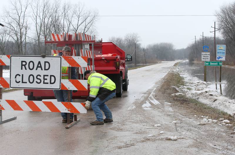 La Salle County Highway Department workers move barricades to close Dee Bennett Road on Friday, Jan. 26, 2024 near the La Salle County Nursing Home. La Salle County Highway Department has closed Dee Bennett Road from the intersection of North 2803rd Road and Dee Bennett west to Utica.