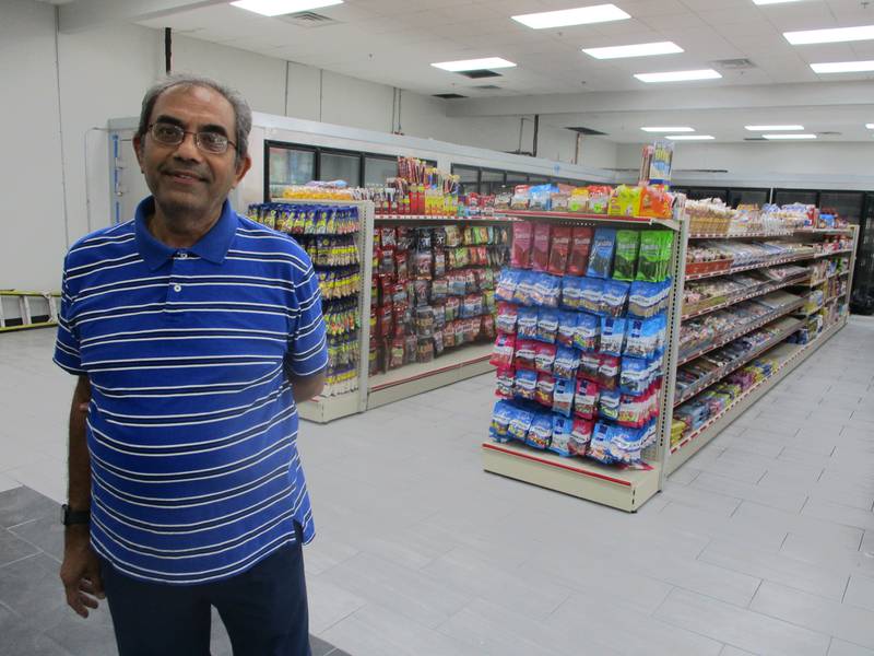 Kamlesh Patel, owner of the Chicago Street Plaza at 410-426 S. Chicago St. in Joliet, poses in front of the shelves stocked for the Osho Food Mart coming into space he has leased at the plaza.