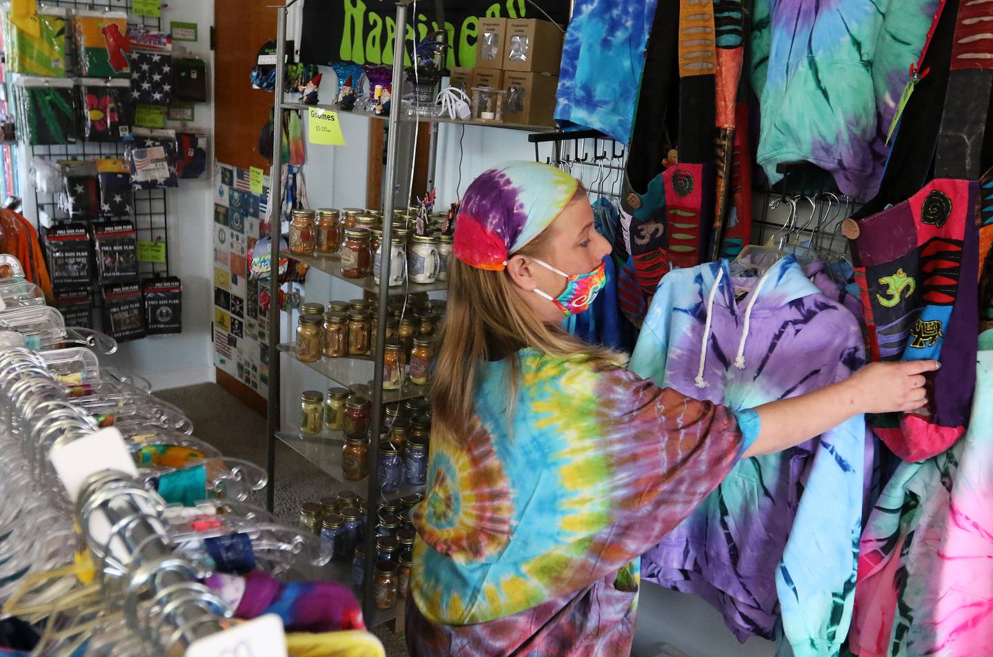 Kim, co-owner of Water Street Shoppe, tidies up the shelves and racks at her store on Court Street on Thursday, April 15, 2021, in McHenry.