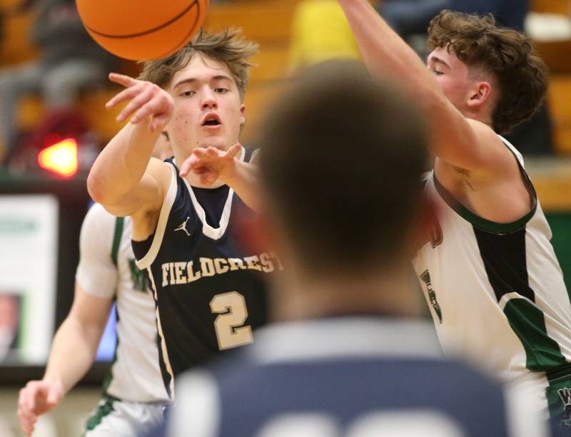 Fieldcrest's Braden Hahn passes the ball to teammate Layten Gerdes as Midland's Owen Laroe defends on Wednesday, Feb. 19, 2025 at Midland High School.