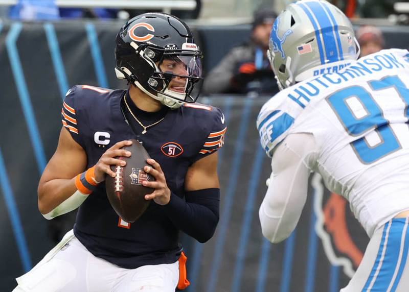 Chicago Bears quarterback Justin Fields looks for a receiver as Detroit Lions defensive end Aidan Hutchinson pressures him during their game Sunday, Dec. 10, 2023 at Soldier Field in Chicago.