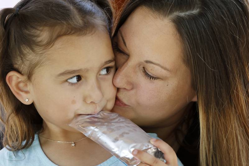 Kristin Glauner gives daughter Evelyn, 4, a kiss on the cheek at home on Thursday, June 3, 2021 in Crystal Lake. Cesar Mauricio Elizarraraz, father of the five children with fiancee Glauner, could potentially be deported back to Mexico on Friday.
