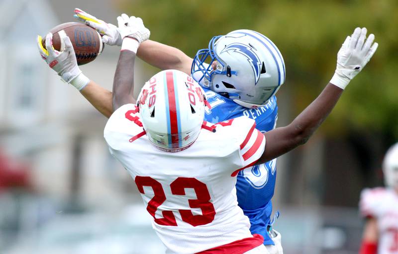 Woodstock’s Keaton Perkins and Ottawa’s Keevon Peterson (23) tussle for a pass in varsity football at Larry Dale Field on the campus of Woodstock High School Saturday. Perkins caught the ball but the play was called back on a penalty.