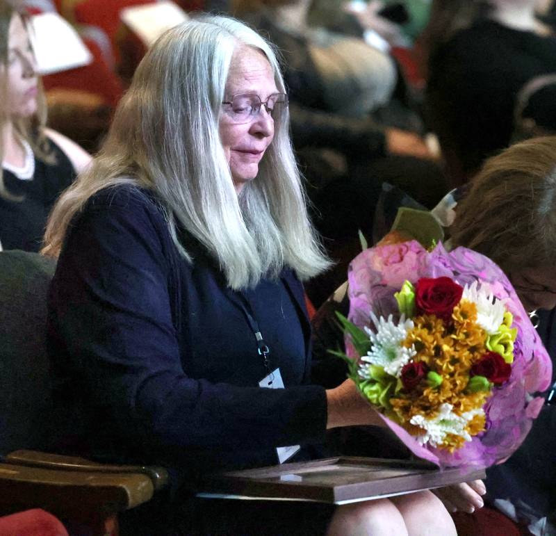 Kathy Dombek (left) holds her flowers after being honored as a Woman of Accomplishment Thursday, Oct. 16, 2025, during the 35th annual Athena and Women of Accomplishment Award Reception at the Egyptian Theatre in DeKalb.