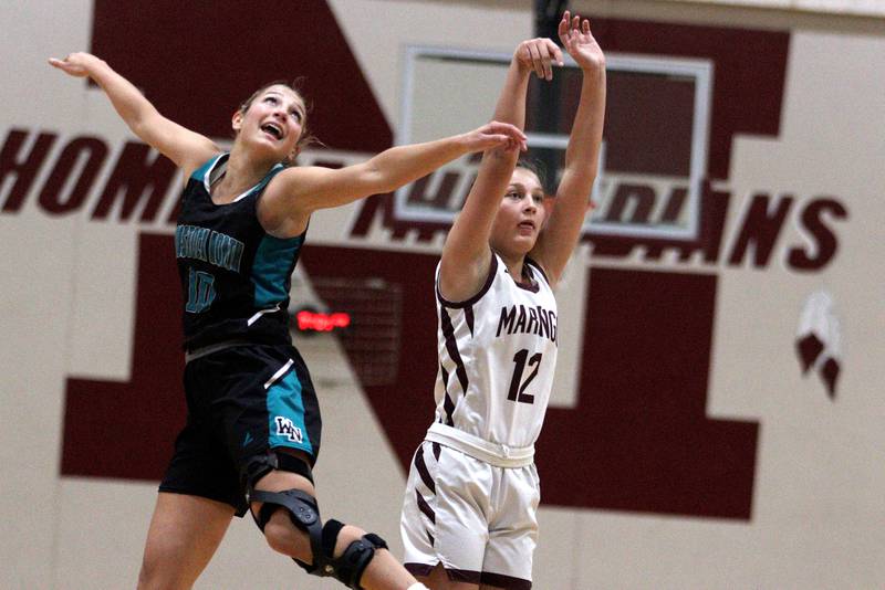 Marengo’s Gabby Gieseke, right, takes an outside shot as Woodstock North’s Addison Rishling defends in varsity girls basketball at Marengo Tuesday evening.