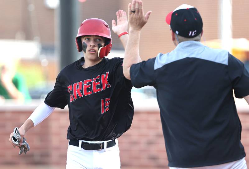 Indian Creek's Kalab Helgesen is congratulated after scoring a run Monday, May 16, 2022, at Hinckley-Big Rock High School during the play-in game to decide who will advance to participate in the Class 1A Somonauk Regional.