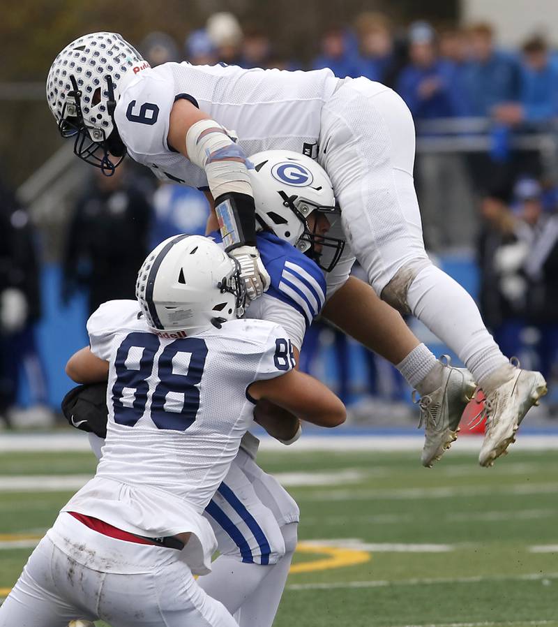 Cary-Grove's Quintin Witt and Charles Ciske (in air) sack Geneva’s Anthony Chahino during an IHSA Class 6A semifinal football game on Saturday, Nov. 23, 2024, at Geneva High School.