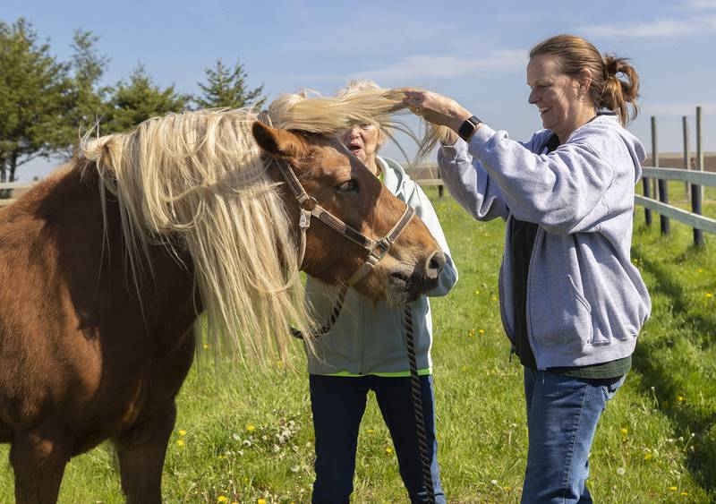 Instructor Kim Paprocki fixes the messy mane of a horse Tuesday, May 6, 2025, at Pegasus Special Riders.