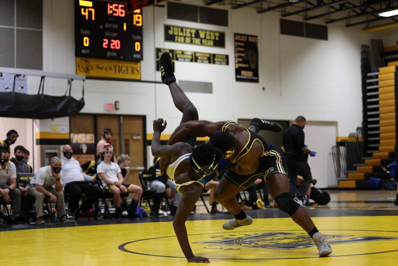 Bryan McCoy of Joliet West (right) takes down Mikai McIntosh of Joliet Central en route to pin in the first period of the 220-pound match Thursday.