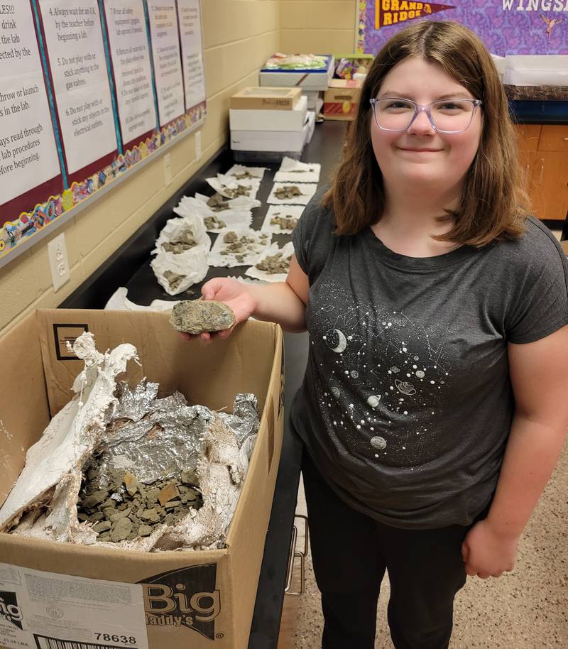 Grand Ridge seventh grade student Lucille Alexander displays the largest of the pieces of the triceratops fossil she found in Montana over the summer.