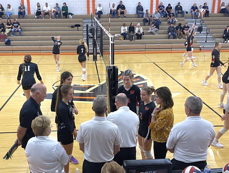 The Cornerstone Christian (at left) and Woodland (at right) captains and coaches – namely for Woodland (left to right) Malayna Pitte, Ella Derossett and head coach Michelle Pitte – meet for prematch instructions Wednesday, Oct. 30, 2024, in Flanagan.
