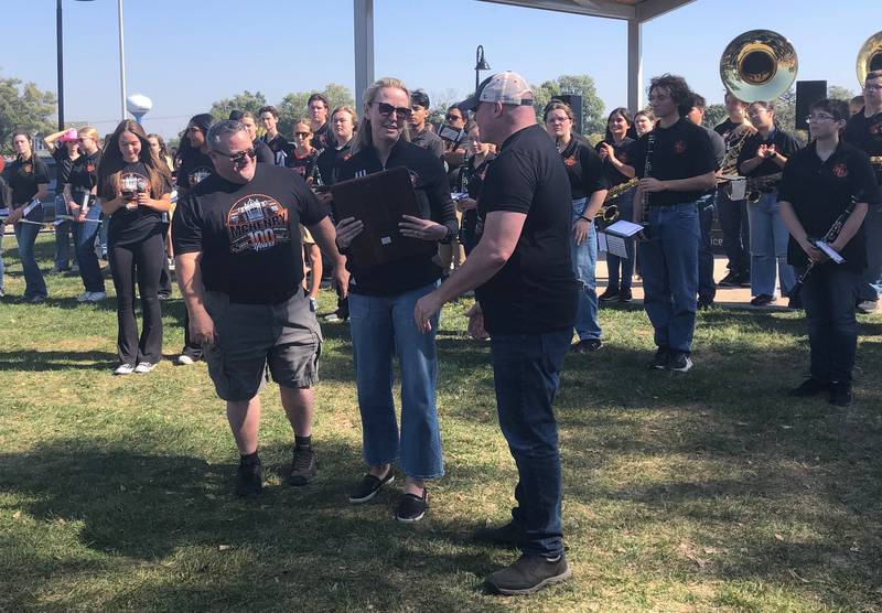 The McHenry High School 2024 distinguished graduate Erica Borggren gets a plaque at the Homecoming rally at Miller Point Park in McHenry Oct. 6, 2024.